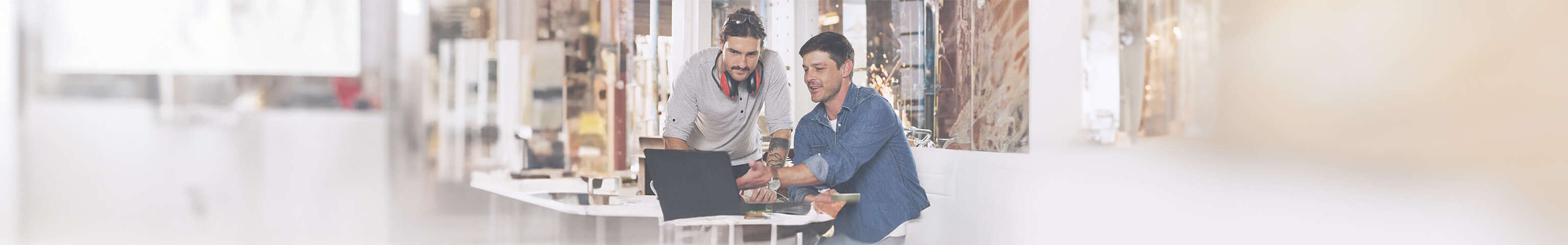 Zwei Männer schauen auf einen Laptop