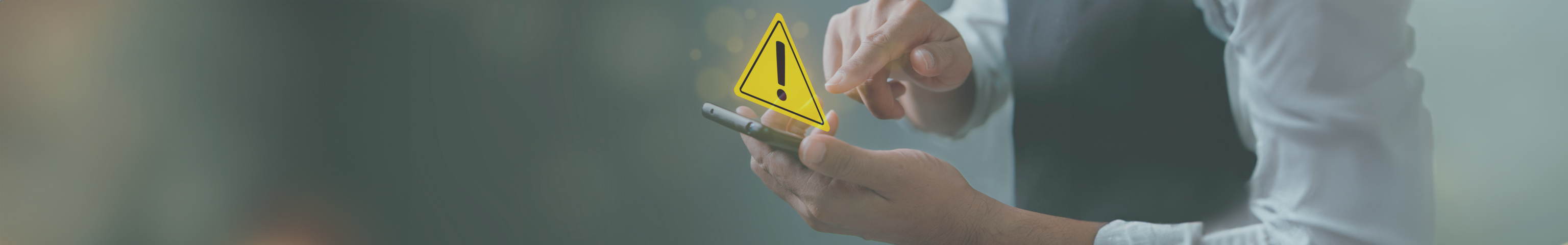 Person tippt auf ein Smartphone, ein gelbes Warnzeichen erscheint im Vordergrund