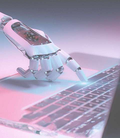 Finger eines Roboters tippt auf Laptop