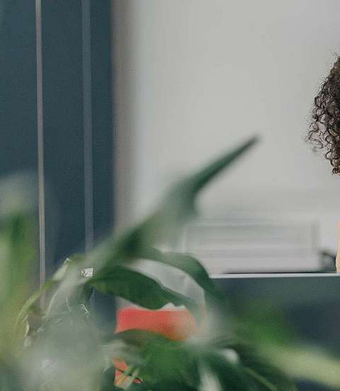 Frau sitzt vor ihrem Laptop