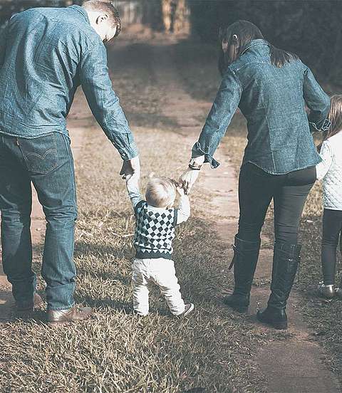Familie spaziert auf einer Wiese